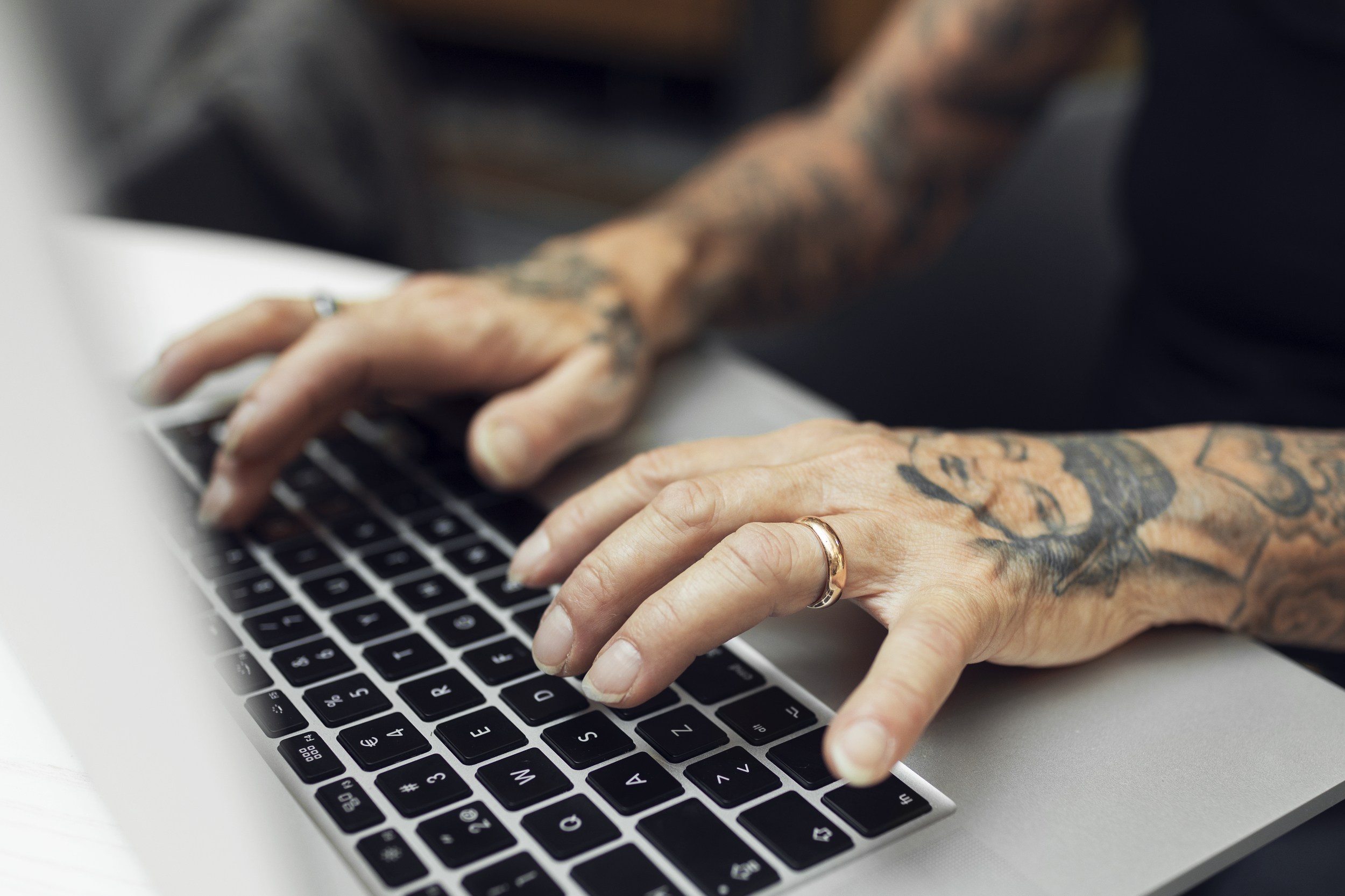 tattooed hands on keyboard