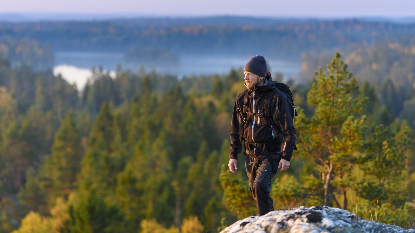 Friluftsklädd man på en bergstopp