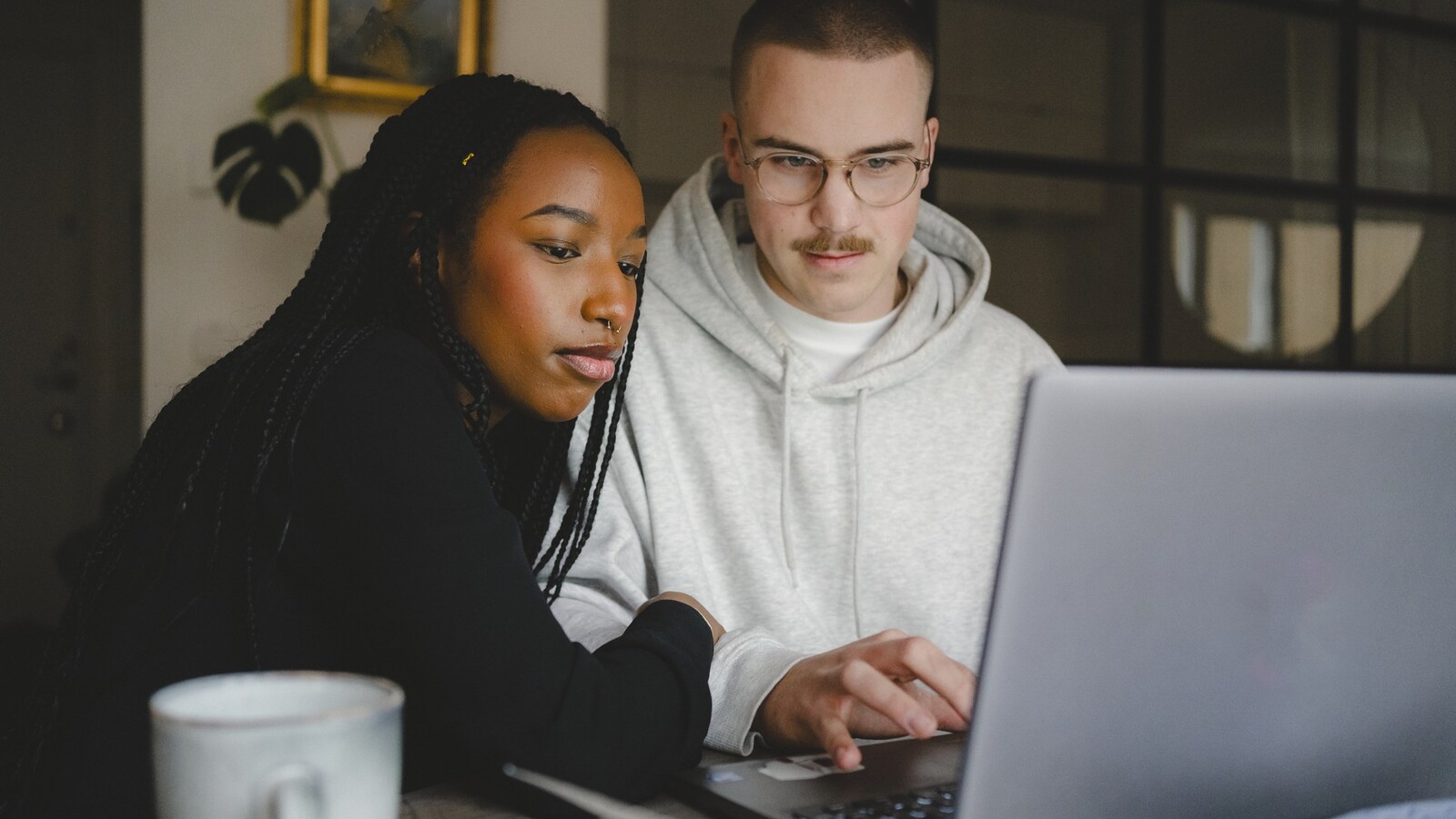 Two young people sitting in front of laptop