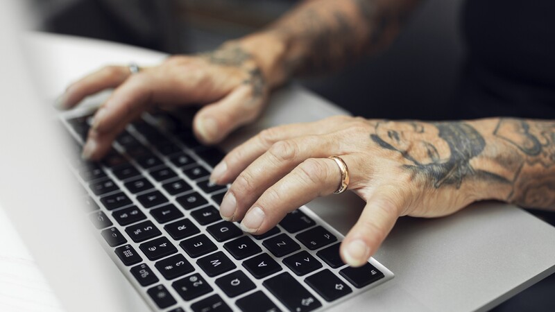 tattooed hands on keyboard