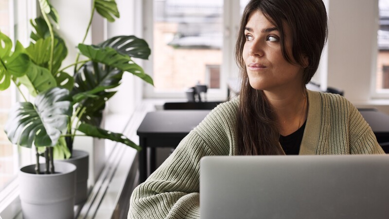 Woman at computer looking out the window.