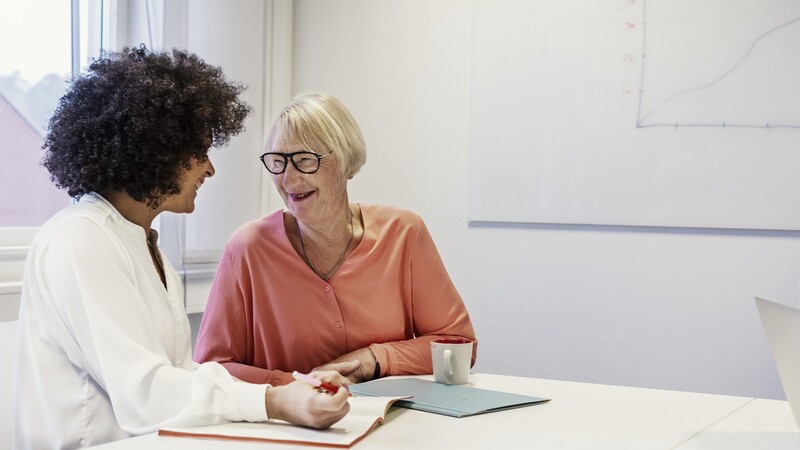 two female colleagues are conversing in the office