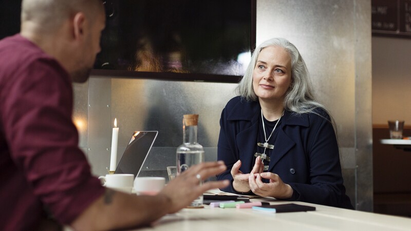 Man and woman at a table in conversation.