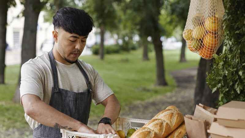 Man in front of basket with fruit and bread