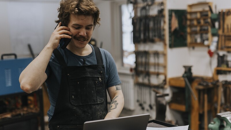 Man talking on the phone and looking at a computer