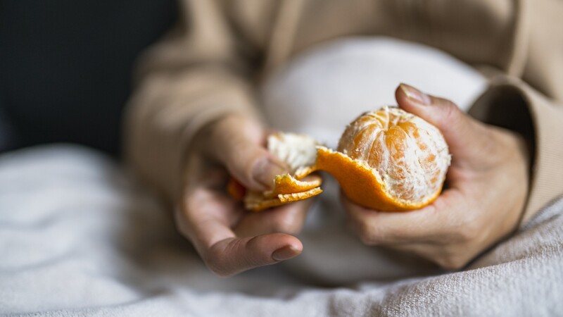 händer skalar citrusfrukt