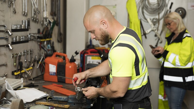 two people in a workshop with yellow clothes