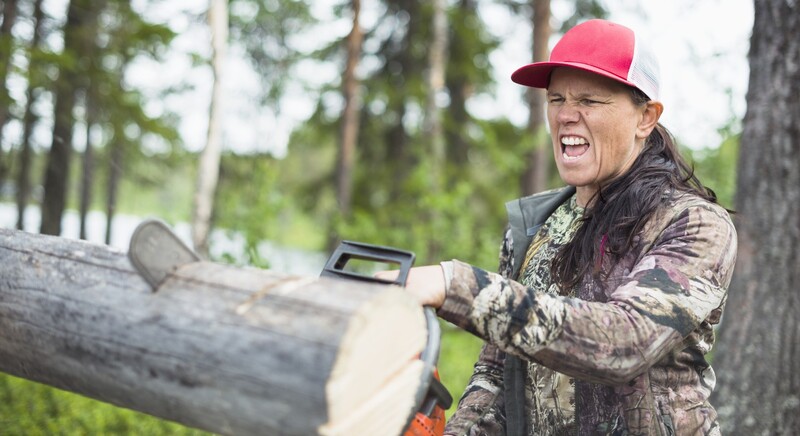 Kvinna som sågar med en motorsåg